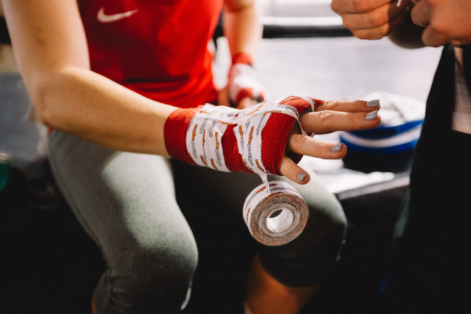 gants de boxe rouges et blancs enrobés de bandes de protection