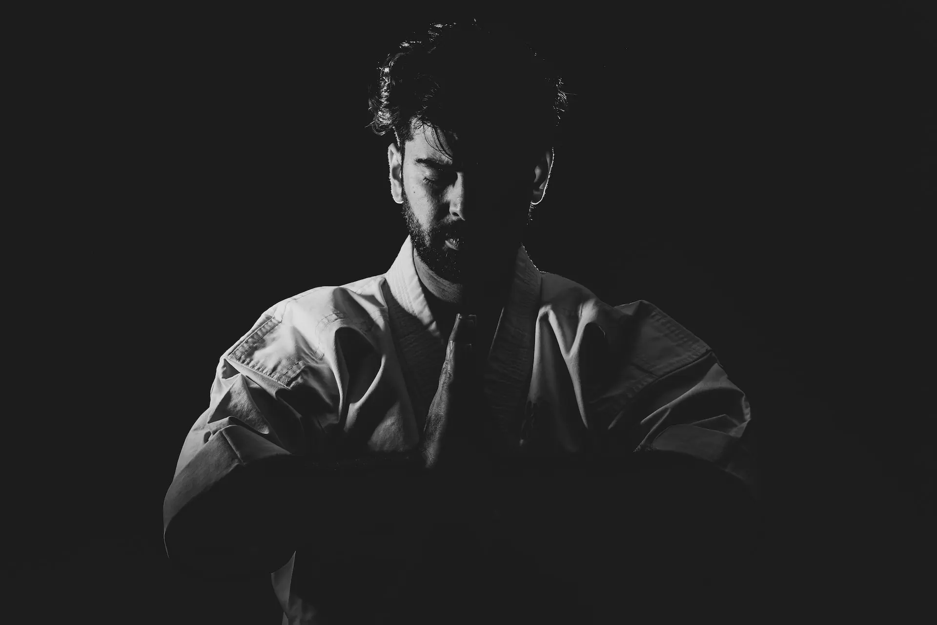 portrait en noir et blanc d'un homme barbu en tenue de combat, arts martiaux