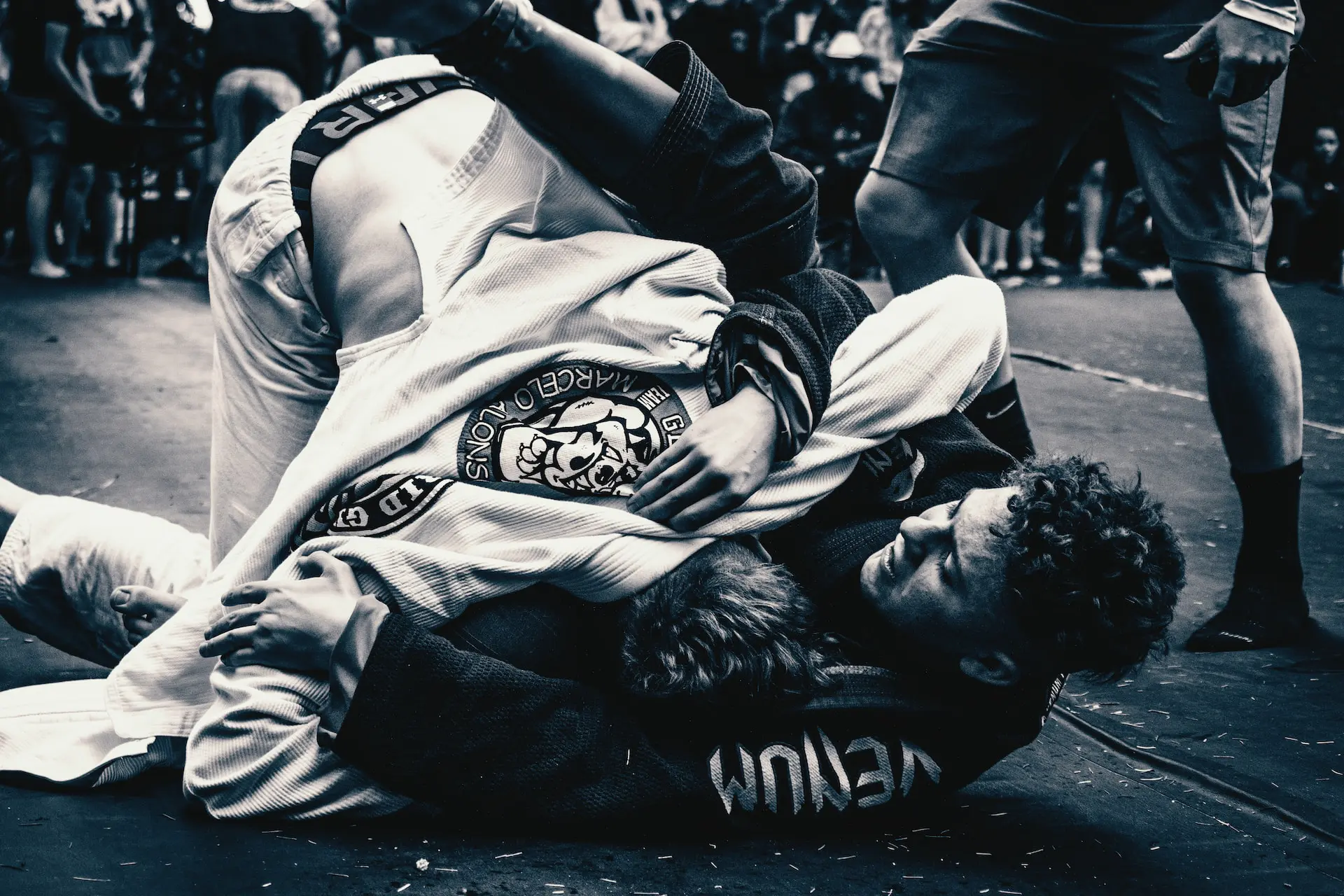 deux pratiquants de jiu-jitsu brésilien en gi blanc et noir lors d'un entraînement au sol