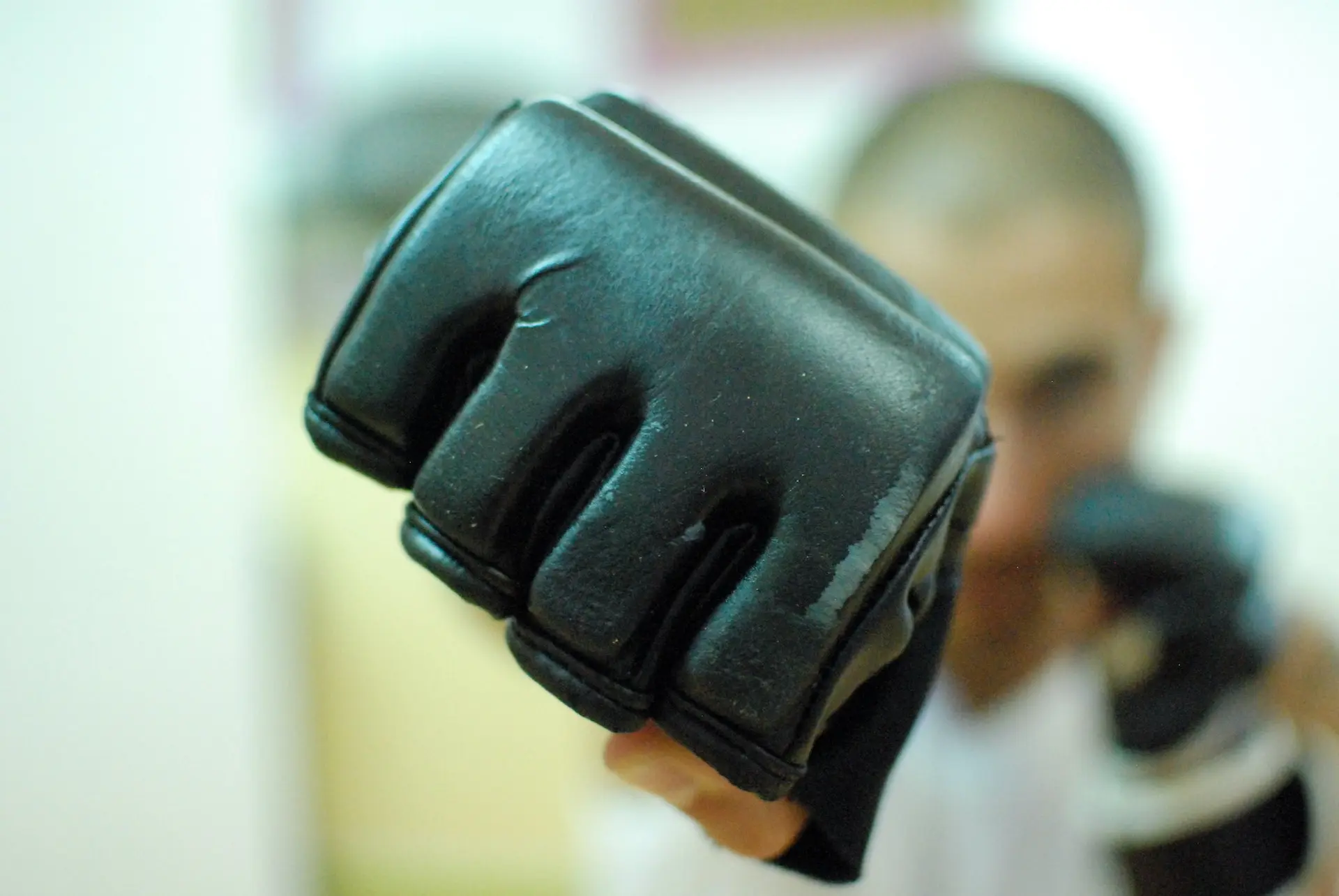 gant de boxe noir porté par un combattant en position de frappe