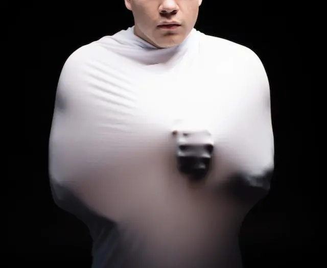 jeune homme en tenue de sport regardant vers le bas, expression déterminée et concentrée