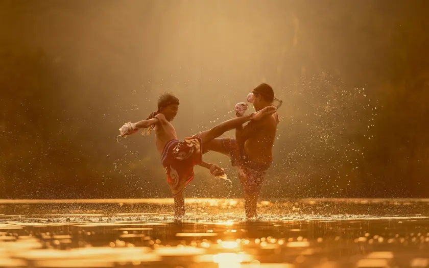 deux enfants s'entraînent à la boxe chinoise dans l'eau au coucher du soleil
