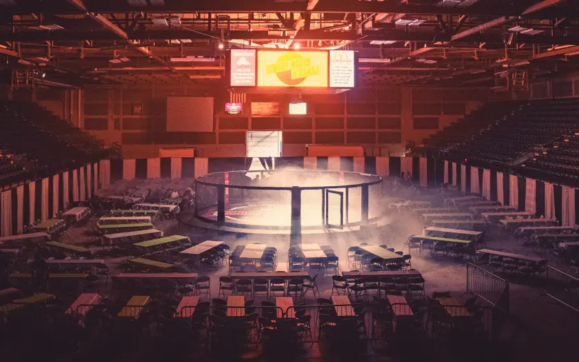 octogone de combat mma avec chaises et écran vidéo dans une arène illuminée