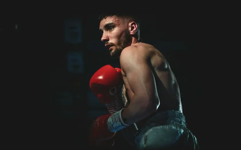 boxeur en position de garde avec gants rouges sur fond noir