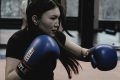femme en gants de boxe bleus lors d'un entraînement de combat