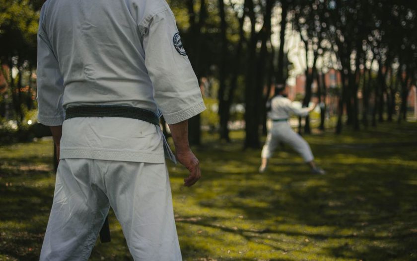 Karate practitioners honing skills in a Colombian park, highlighting focus and tradition.