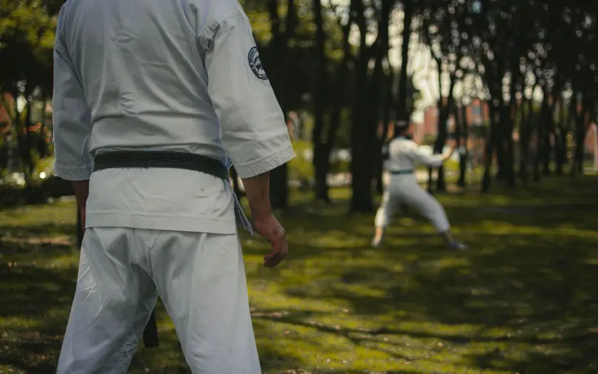 Karate practitioners honing skills in a Colombian park, highlighting focus and tradition.