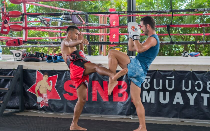 a couple of men standing next to each other in a boxing ring