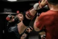 2 men in red and black boxing gloves